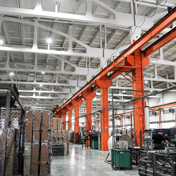 Spacious industrial plant interior featuring machinery and metal frames with a high ceiling.