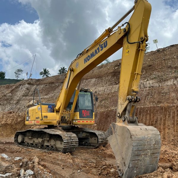 Yellow Komatsu bulldozer working at a construction site in Surakarta, Central Java under a cloudy sky.